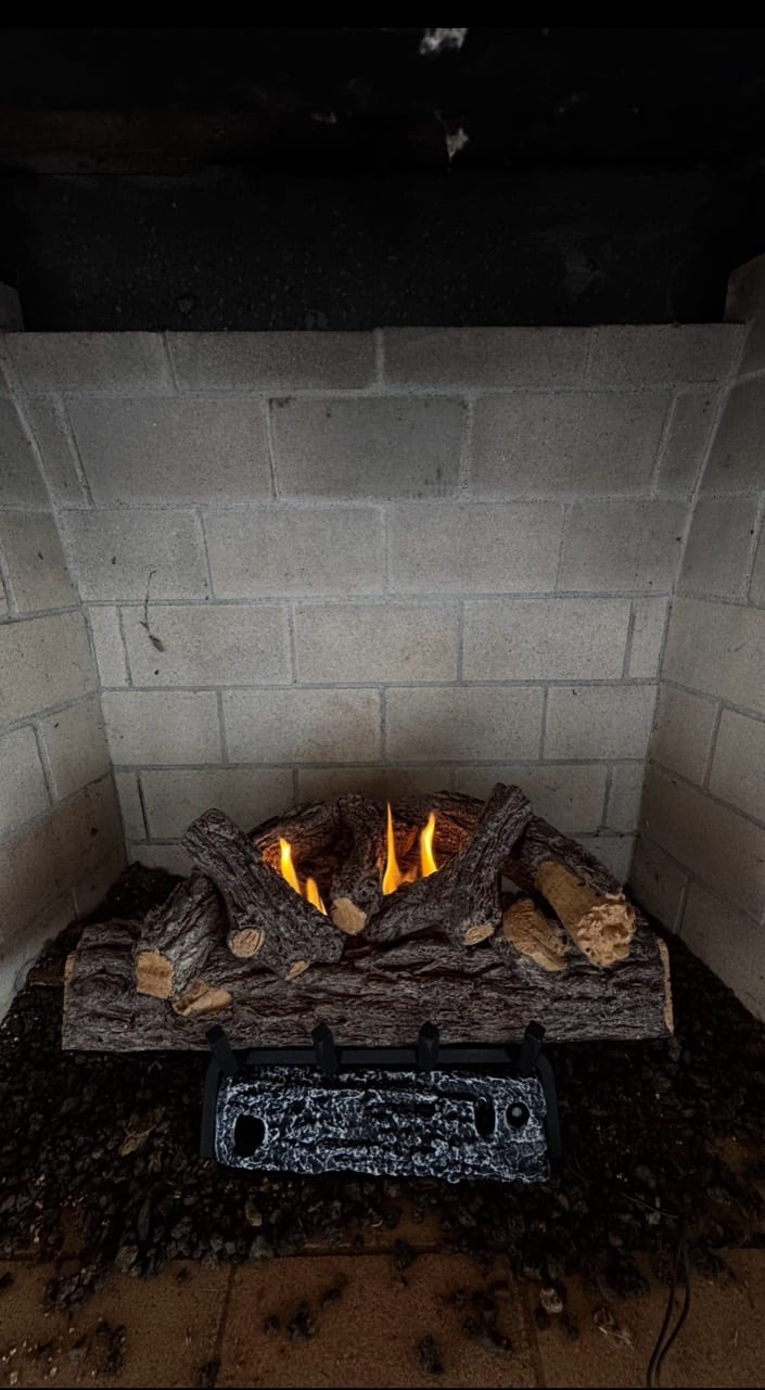 A gas-log fireplace with glowing amber flames